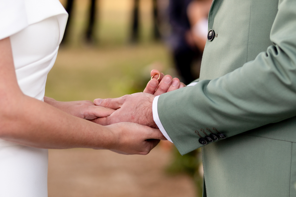 Novios felices durante ceremonia en Estancia Villa María detalle manos